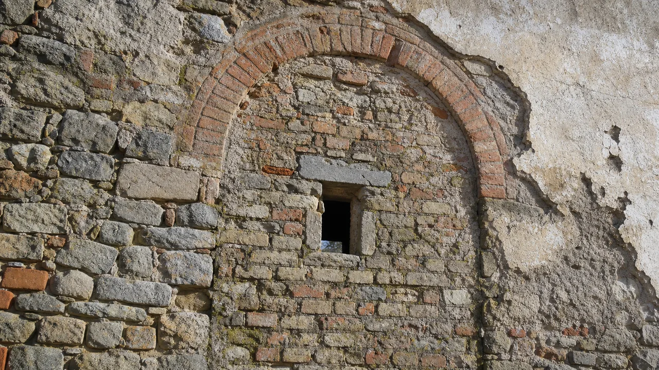 Arco in mattoni tamponato nella facciata di un fabbricato rurale — cambio destinazione uso rustico