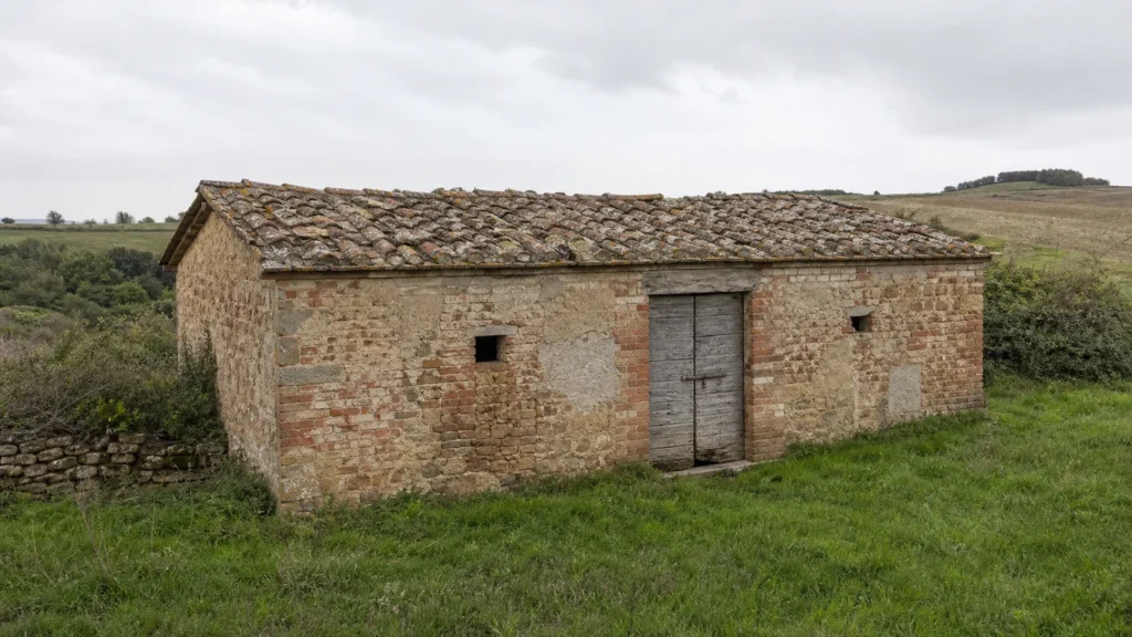 Piccolo rustico in muratura mista con copertura in coppi in un contesto agricolo